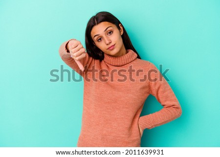 Young Indian woman isolated on blue background showing thumb down, disappointment concept. Royalty-Free Stock Photo #2011639931