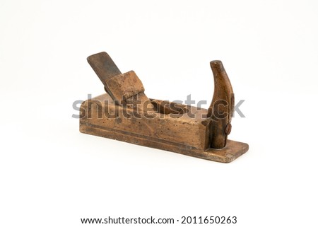 Horizontal high angle angle studio shot of small vintage wood planer isolated on white background. Old carpenter tool with wood worm holes in it. Carpentry concept. Royalty-Free Stock Photo #2011650263