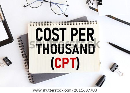 COST PER THOUSAND, text on notepad. on a white background near the stationery