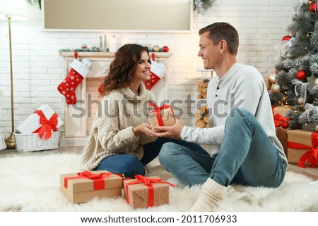 Happy couple with Christmas gift at home