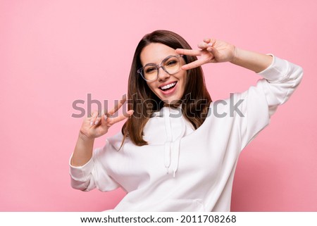 Photo of shiny pretty young lady wear white hoodie glasses smiling v-signs cover eyes isolated pink color background Royalty-Free Stock Photo #2011708268