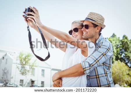 Stylish young couple taking a selfie on a sunny day in the city