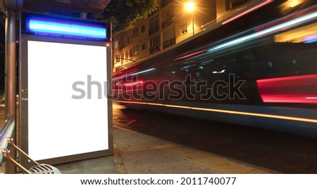 Billboard with light in the city center at night, with bus in motion