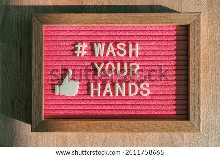 Wash your hands hashtag message on felt billboard board at business store good hand hygiene for coronavirus prevention. Felt sign for social media against COVID-19.