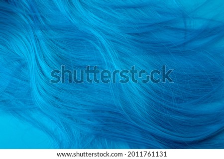 Anime and manga fashion, feminism and and social justice warrior concept with vivid turquoise coloured artificial hair isolated on blue background with copy space