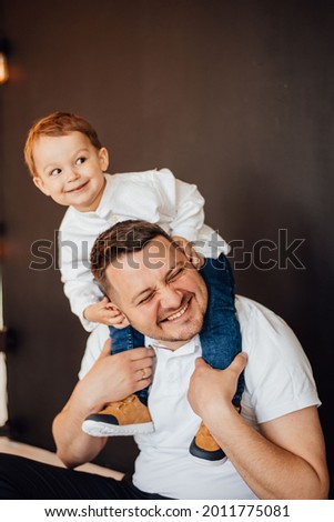 The son sits on the shoulders of the dad. family photography