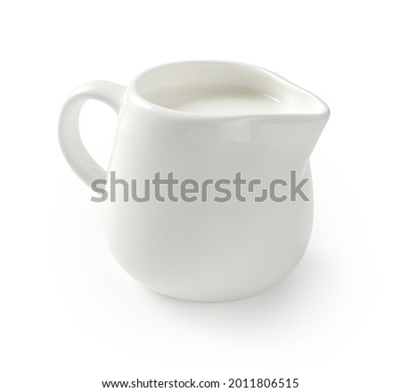 Ceramic milk jar isolated on white background. Milk pitcher for package design. Porcelain creamer pitcher with milk on white. Royalty-Free Stock Photo #2011806515