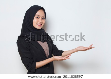 Young asian muslim business woman wearing hijab smiling confident pointing with fingers to different directions