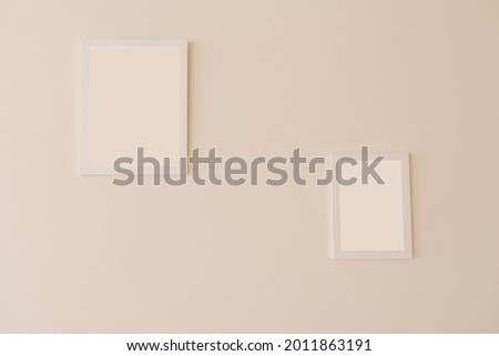 White mockup frames on a beige wall of different sizes