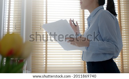 Young female leader, asia people lady or mba student happy standing smile look at in front of mirror pep talk for sale pitch hold paper document script public speak skill for job career self improve. Royalty-Free Stock Photo #2011869740