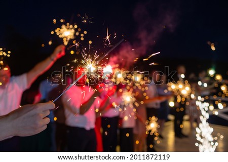 Picture showing group of friends having fun with sparklers.