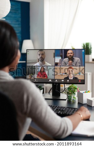 Black woman sitting at desk working remote at marketing course ideas discussing with virtual univeristy team during online videocall meeting conference, Student using high school elearning platform Royalty-Free Stock Photo #2011893164