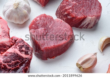 Fresh raw fillet minion steaks marbled beef with rosemary and garlic set, on white stone  surface