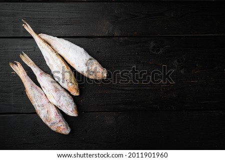 Frozen Goatfish raw fish set, on black wooden table background, top view flat lay , with copy space for text