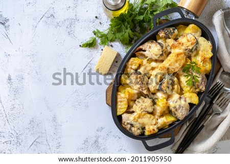 Baked mackerel with potatoes and cheese on a marble tabletop. 
Top view flat lay background. Copy space.