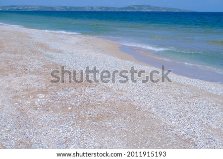 Waves on the sandy seashore are a beautiful summer background. Design of the background, photo wallpapers, covers, screensavers.
