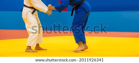 Two judo fighters in white and blue uniform. Horizontal sport poster, greeting cards, headers, website Royalty-Free Stock Photo #2011926341