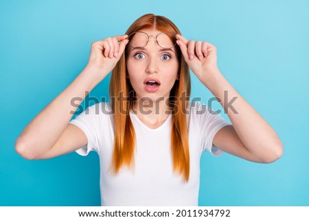Photo of young girl hands touch glasses amazed surprised fake novelty news isolated over blue color background