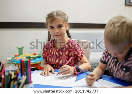 A lefty girl and righty boy writing at the same desk and nudge each other with elbows, international left-hander day celebration, only lefties understand Royalty-Free Stock Photo #2011942937