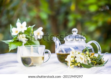 Philadelphus or garden jasmine flowers, healthy herbal tea cup of hot tea. Romantic dinner with therapeutic fragrant tea. Soft focus