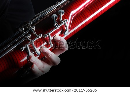 Bassoon woodwind instrument with player hand details. Orchestra musical instruments close up Royalty-Free Stock Photo #2011955285