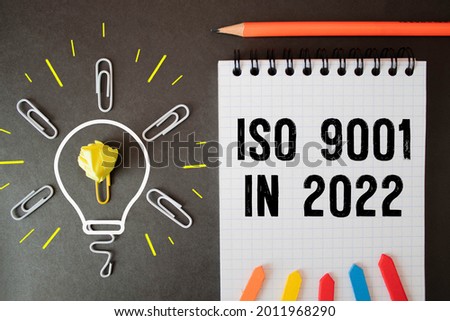 Notepad with text ISO 9001 in 2021. Diagram and white background