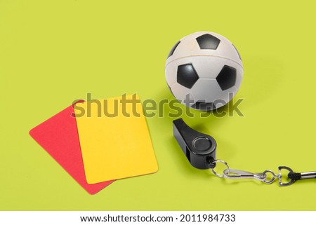 Soccer ball, yellow and red cards and referee whistle