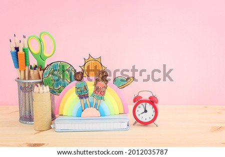 Back to school concept. Top view image of two kids and Stationery over wooden desk