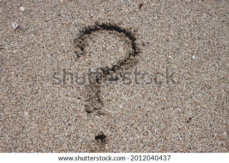 question mark drawn in the sand