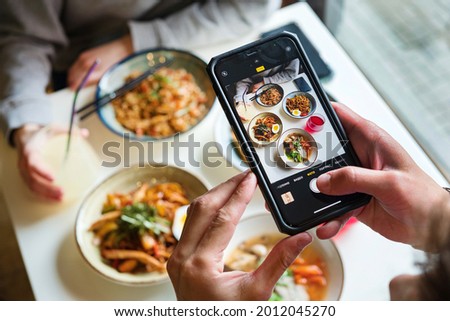 close up of woman with smartphone taking picture of dessert at restaurant