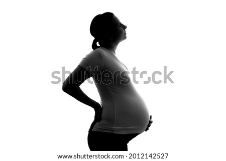 Pregnant caucasian woman touching her belly. Waiting for baby