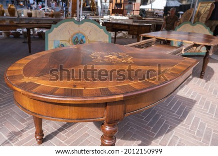 Furniture on flea market in Arrezo, antique inlaid table Royalty-Free Stock Photo #2012150999