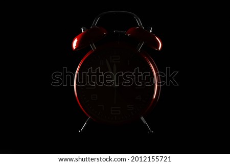 Silhouette of alarm clock on dark background