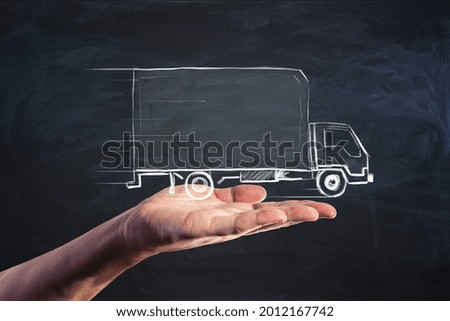 Delivery service and moving concept with handwritten truck on human palm on plain dark background