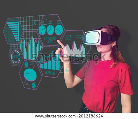 Slim young lady wearing VR glasses, isolated on a neutral background,  touching the hologram of the interface. Data analysis in virtual reality. Financial statistics, demonstration