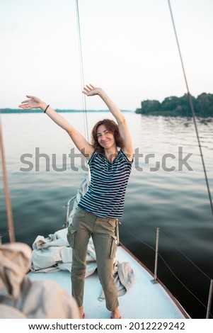 Smiling girl on a yacht, young woman having fun on a yacht, portrait of a woman against the background of the sea and sky