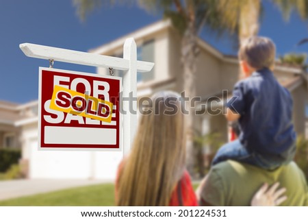 Curious Family Facing Sold For Sale Real Estate Sign and Beautiful New House.