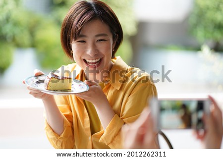 Woman holding a cake and taking a picture 