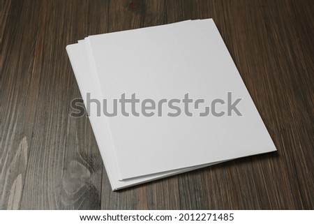 Stack of blank paper sheets on wooden table. Brochure design