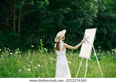 woman artist in nature draws a picture