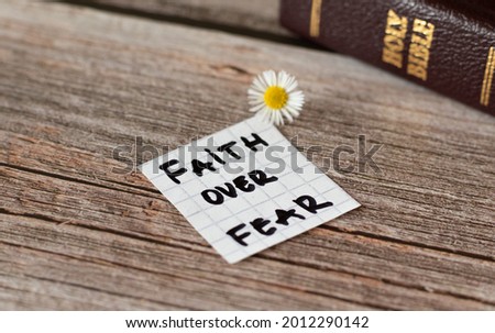 Faith over fear. Inspiring handwritten quote from the Bible Book. Trust, faith, hope, belief in God and Jesus Christ. Devoted faithful Christian biblical concept. A closeup. Royalty-Free Stock Photo #2012290142