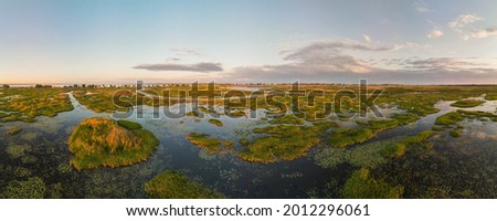 Aerial panoramic sunset sunrise scene at swamps and wetlands of Big Creek National Wildlife Area near Long Point Provincial Park, Lake Erie shore. Royalty-Free Stock Photo #2012296061