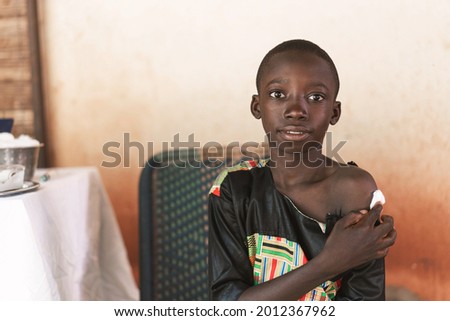 Relieved little black boy after having received a vaccine during a routine childhood immunisation schedule in a rural hospital setting Royalty-Free Stock Photo #2012367962