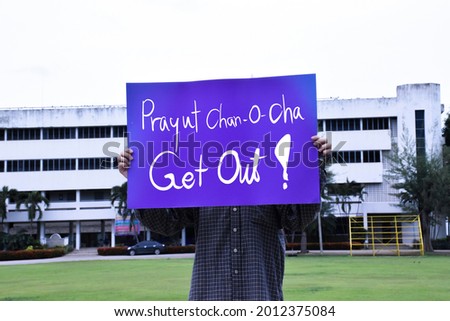 Thai male holds card ‘Prayut Chan-O-Cha Get Out!, concept for protesting to call out Thai Prime Minister Prayut Chan-o-cha to resign from his position due to the failed management of covid-19 crisis.