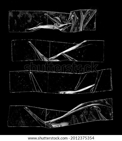set of transparent adhesive tape or glue strips isolated on black background, crumpled plastic sticky snips, real macro photo. Royalty-Free Stock Photo #2012375354