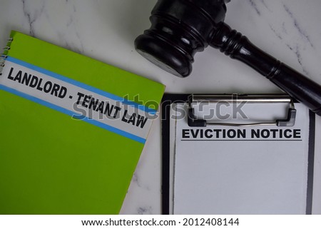 Eviction Notice on Document and Book Landlord-Tenant Law isolated on Wooden Table.