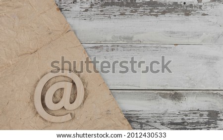 An email sign on a old white wood lies on a vintage wooden table. Concept e-mail message letter. Top view with copy space