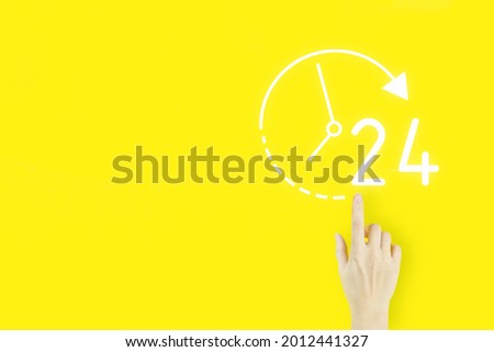 Full time service concept. Young woman's hand finger pointing with hologram 24 7 all day all night icon on yellow background. Business button 24 hours service.