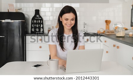 Young caucasian female worker freelancer student tutor business woman working on laptop, watching webinars, doing homework, listening to lectures, podcast remotely on lockdown
