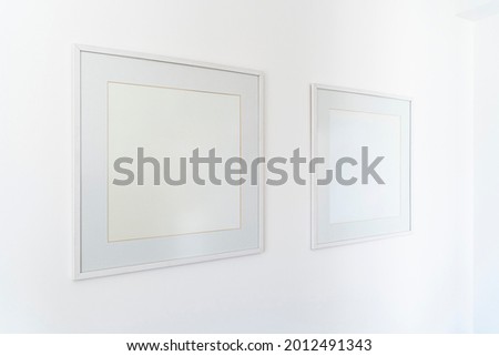 Empty square white frame, poster white canvas mock up on a white wall, living room, template angle view gallery, home decoration